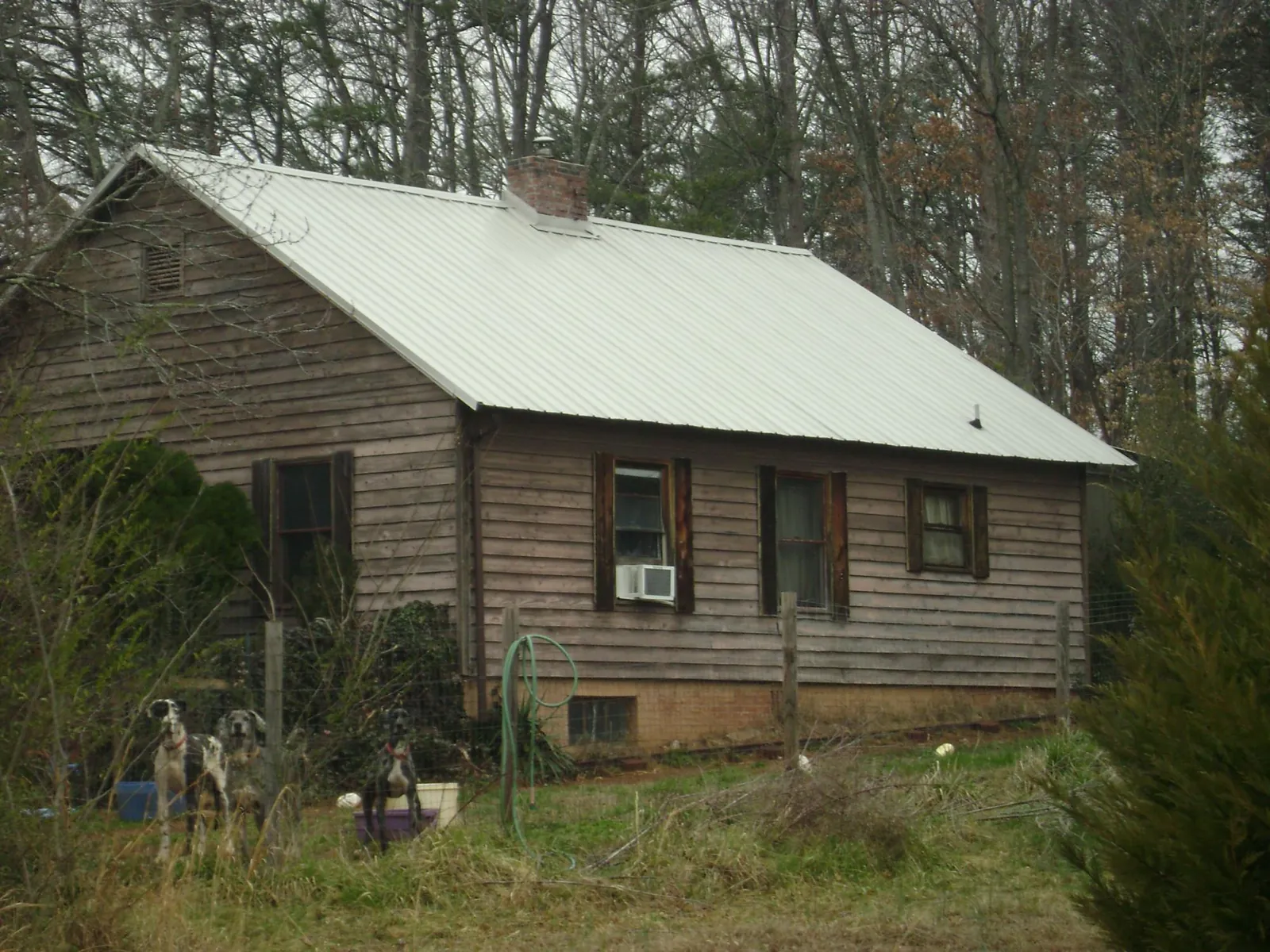 White metal roof on an old wood sided farmhouse, from a Metal Roof Installation job in Brimfield